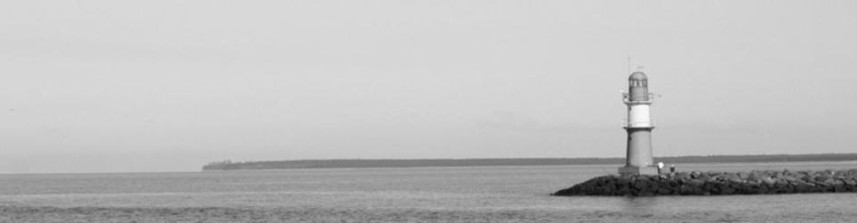 Ein Leuchtturm steht am Meer.